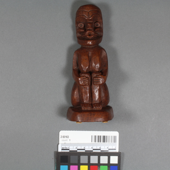 Hearst Museum object titled Figurine cast, accession number 2-50163, described as Figurine; cast plaster in form of seated figure, painted brown; figure holds knees. Represents "Tsonoqua", "the wild woman". Label on bottom says: "crafted by Shamans".