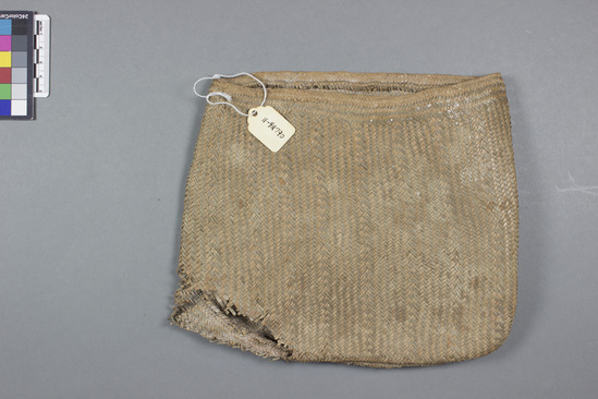 Hearst Museum object titled Fiber bag, accession number 11-42790, described as Bag, coconut leaves, plaited, seam at bottom, brown and tan; torn; no handle. 18.5 cm.