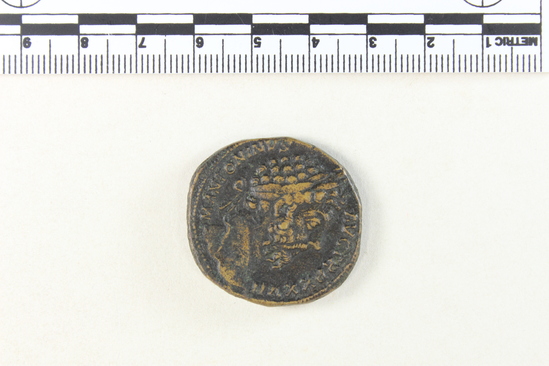 Hearst Museum object 8 of 8 titled Coin: æ sestertius, accession number 8-5521, described as Coin; AE; Sestertius; Roman. 25.82 grams, 31.5 mm. Marcus Aurelius Antoninus, 172-173 AD. Rome, Italy. Obverse: M ANTONINUS AUG TR P XXVII, bust r. laureate. Reverse: JIMP VI COS III, upiter, naked to waist, seated facing l. on throne, holding Victory and scepter; in exergue, SC.