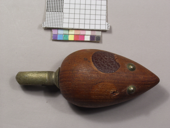 Hearst Museum object titled Bottle opener, accession number 2-69049, described as Home bar tool. Caplifter, zoomorphic; turned wood caricature of mouse, brass tacks as eyes, one leather ear (other missing); aluminum tail as crown caplifter; 8.8 cm long