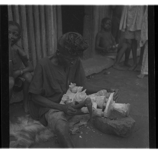 Hearst Museum object titled Black-and-white negative, accession number 15-30902, described as Black and white negative, 2.25'' Nigeria, Meko, Duga working on Oshe Shango, 1951