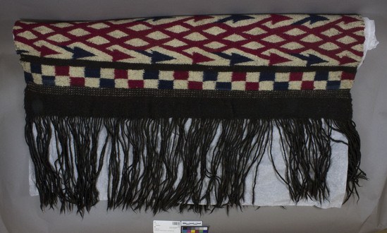 Hearst Museum object 2 of 2 titled Chamarro, accession number 3-12, described as Chamarro of native; wool; twill and tapestry weaves; brown, white, red, blue; long fringe; approximately 2 m long and 90 cm wide REMARKS: Ornamentation ancient