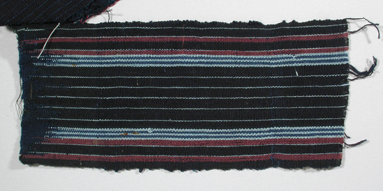 Hearst Museum object titled Textile fragment, accession number 5-11104, described as Textile sample (section of narrow band weaving): Black waft/ navy weft ground; two maroon stripes ea. side; two stripes blue alternating with three stripes pale blue ea. side; pale blue lines throughout.