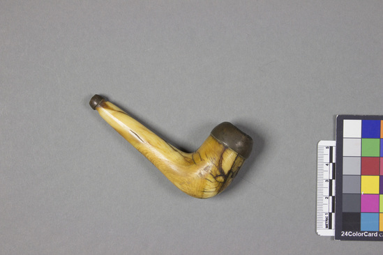 Hearst Museum object titled Ivory pipe, accession number 11-1904, described as Whale ivory. Metal piece attached to rim of bowl and tip of stem.