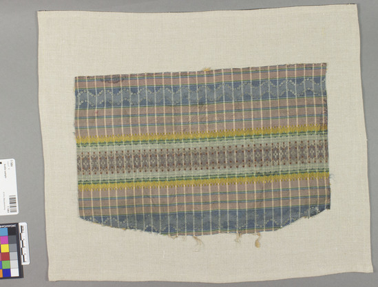 Hearst Museum object titled Textile sample, accession number 7-7484, described as Framed piece. Silk. Plain weave, brocaded. Varicolored, striped and checked. Geometric designs, Tobine type brocade. 11 3/8 by 7 5/8".