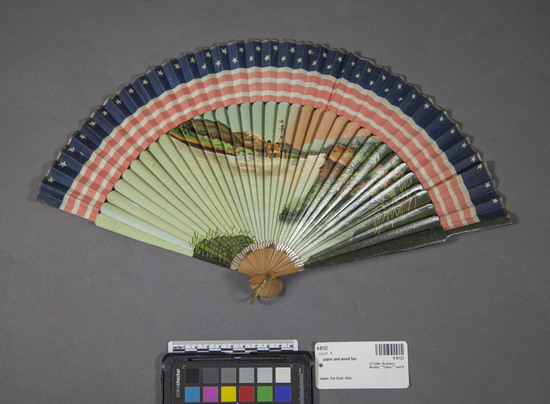 Hearst Museum object titled Fan, accession number 9-8122, described as Fan, narrow cloth strip on front showing stars and stripes, long bamboo ribs enameled w/picture of U. S. gunboat (Perry?) entering Japan, 22.2 cm. l.