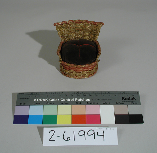 Hearst Museum object titled Pincushion, accession number 2-61994, described as Basketry chair. Made of ash checker plait, natural and red; layered with sweetgrass braid; brown velvet cushion. Written in ink on underside "Passamaquoddy", "Maine,1971", and the number "SS6A".