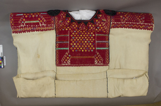 Hearst Museum object titled Huipil, accession number 3-23458, described as Huipil; three-width; white cotton plain weave; brocade design mostly red; half way down on centerpiece, wide mano on sides; typical black silk rosettes on mano and in "sun" design around neck opening; 73 x 83.9 cm. Perfect example of huipil from this area.