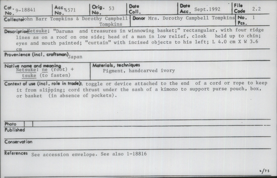 Documentation associated with Hearst Museum object titled Netsuke, accession number 9-18841, described as Netsuke; "Daruma and treasures in winnowing basket;" rectangular, with four ridge lines as on a roof on one side; head of a man in low relief, cloak held up to chin; eyes and mouth painted; "curtain" with incised objects to his left; L 4.0 cm X W 3.6 cm
