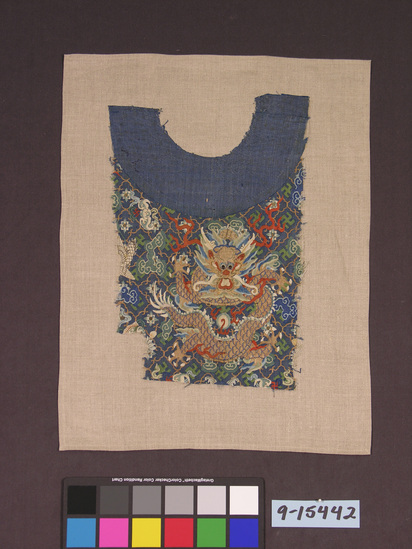 Hearst Museum object titled Textile, accession number 9-15442, described as Fragment of Mandarin coat; silk, paint, gilt paper wrapped silk; K'ossu tapestry weave, parts painted; blue ground, multicolored designs; 17 1/2 by 11 1/2 inches; dragons, pearls, swastikas, birds, bats, floral designs similar to #85.