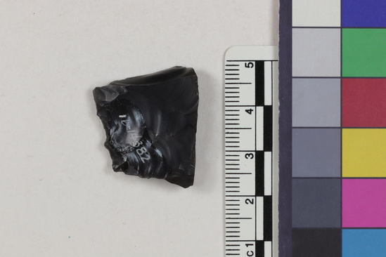 Hearst Museum object 1 of 2 titled Flake fragment, accession number 16-14382, described as Projectile point fragment; obsidian; triangular; weight: 4.35 grams; length: 2.4 cm; width: 2.75 cm; depth: 0.61 cm.