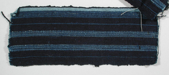 Hearst Museum object titled Textile fragment, accession number 5-11134, described as Textile sample (section of narrow band weaving): cotton; navy ground; two stripes alternating light blue and medium blue; one edge, one band of medium blue and one band of light blue.