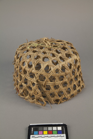 Hearst Museum object titled Basketry cage, accession number 5-13102, described as Chundi., Kenya, Basuba, Boni. August, 1975. 5-13102, acc no. 3174. File code: 1.3 Collector: Jean Colvin. Donor: University appropriation. Materials, techniques: Woven duom palm leaf Context of use: Used for keeping small chickens safe at night- hung in tree to protect from predators. Made by men. Description: Basket; circular shaped, flat sides and bottom; open weave with diamond shaped spaces.