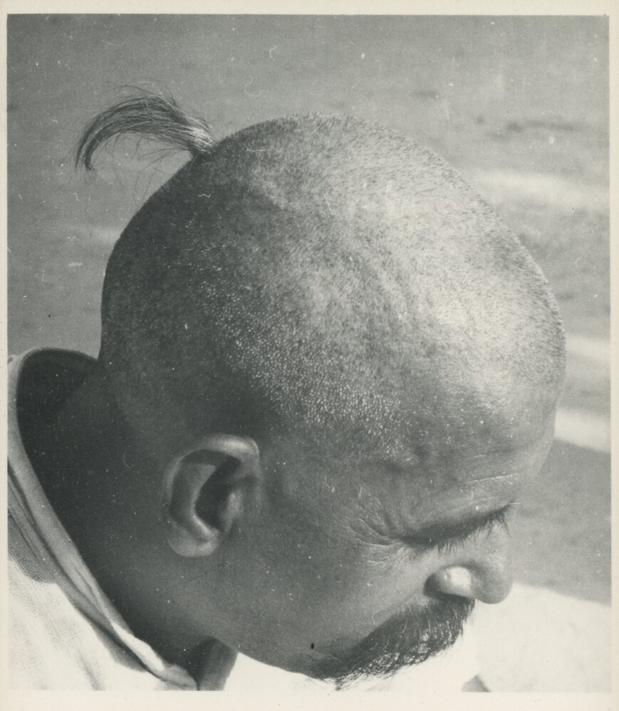 Hearst Museum object titled Black-and-white print, accession number 15-24617, described as Black and white photograph mounted on board.  muuNDNaa: A style of village hair cut in which the hair is shaved by razor or cut all around with scissors without the help of a comb. Worn by Sadhus, hair is also cut this way in the first hair-cutting ceremony.  302a: Hairstyles.  May 1956.