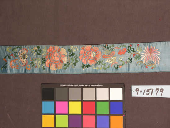 Hearst Museum object titled Textile strip, accession number 9-15179, described as Strip. Silk. Satin,, embroidered. Blue ground, varicolored designs. Flower and bat motives. Same as #292. 3¾ inches by 26 inches.