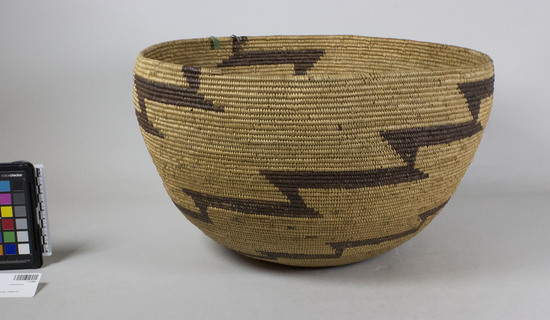 Hearst Museum object 2 of 2 titled Storage basket, accession number 1-11962, described as Large globose coiled basket.  Tag:  "Yuki".  Second tag "1125". Per Ralph Shanks:  Globose coiled basket bowl, probably made for storage, with no residue.  Tight spiral coil start. The coil foundation is rods of peeled shoots, with some splints.  The wefts are peeled redbud with unpeeled redbud designs.  The design includes three diagonal series of connected steps.  There are random rectangles.  The rim is plain wrapped and the coil ending has exposed rods.  The weft fag ends are clipped, concealed or bound under.  The weft moving ends are bound under.  The exterior workface has about 15% split stiches.  The interior back-face of the basket has about 50% split stiches.  The basket has an exterior workface with a rightward direction and a down to the right slant of weft twist.