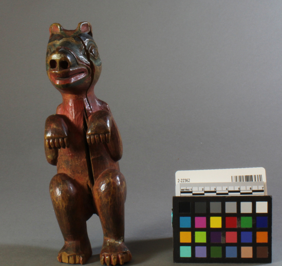 Hearst Museum object titled Zoomorph, accession number 2-22362, described as Wooden figure of a bear in squatting position; red, black, blue-green; frontal split, damaged feet.  "Exceptionally fine work.