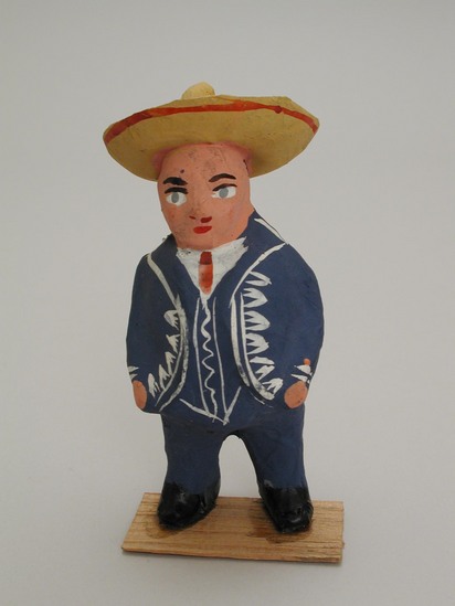 Hearst Museum object titled Male figurine, accession number 3-29138c, described as Figurines.  Men made of paper mache in graduated sizes, each mounted on a thin piece of wood;  painted do that each figure is wearing a bright blue suit with white trimming, a yellow sombrero with red decorations.  (a) H 13 cm;  (b) H 14 cm;  (c) H 14.5 cm