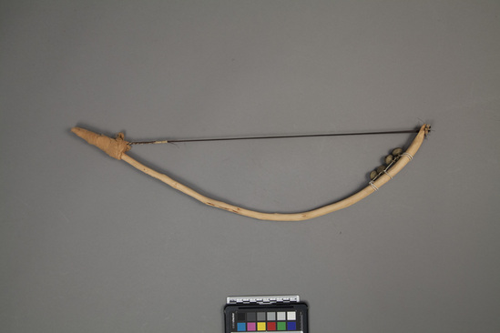 Hearst Museum object 3 of 4 titled Musical bow, accession number 9-10950, described as bow for stringed musical instrument; wood, horsehair, bells, cloth; Length 53 cm.