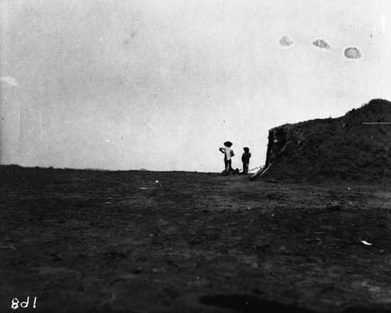 Hearst Museum object titled Black-and-white negative, accession number 15-168, described as Upward view of stone house and silhouetted two male figures (Indians).