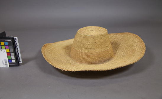 Hearst Museum object titled Hat, accession number 5-17091, described as Woven basketry hat, European style, with board brim, round crown with flat top. A border 1.2 cm wide is of a pale red color, as is a 4.5 cm band around the base of the crown.