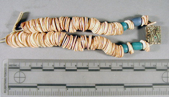 Hearst Museum object titled Beads, accession number 6-19103, described as beads: mass of flat shell discs, four blue glaze, one rectangular pendant with inscription