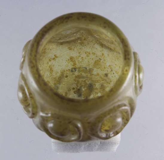 Hearst Museum object 19 of 20 titled Jar, accession number 5-14497, described as Glass jar, mold blown? Pale golg with ochre specks. 7 circle motifs around sides.