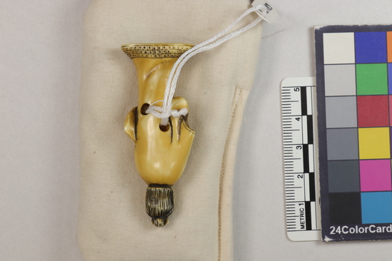 Hearst Museum object 3 of 12 titled Netsuke, accession number 9-18783, described as Netsuke; figure of man, standing, with long robe, flaring at feet; right hand holding robe, left hand concealed; H 6.0 cm X W 2.3 cm