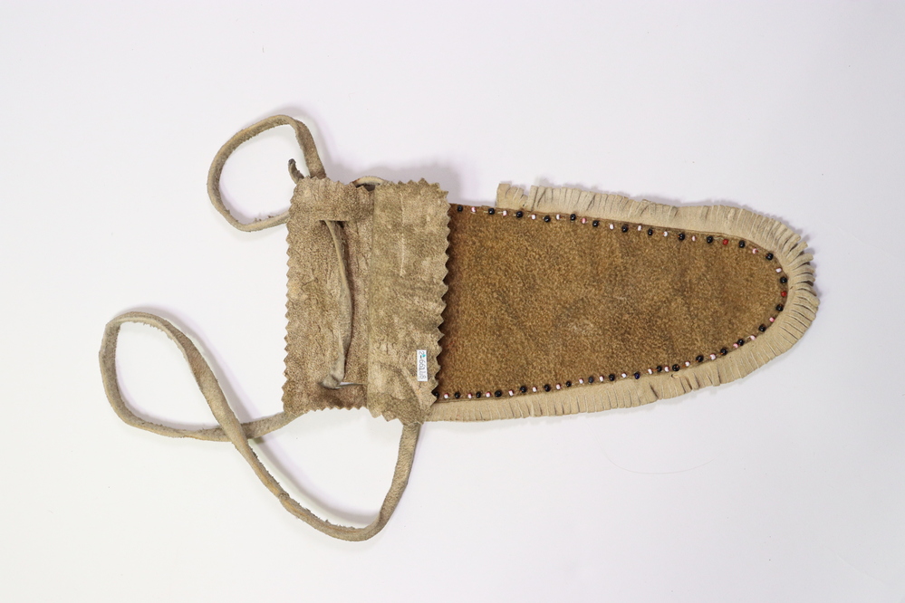 Hearst Museum object titled Sheath, accession number 2-66148, described as For knife. Leather with fringe, glass pony beads stitched around edge, leather thong handle.