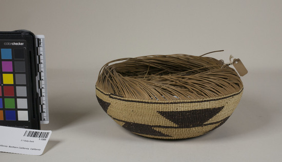 Hearst Museum object 2 of 2 titled Cap, accession number 1-1585, described as Cap basket; twined. Warp is Hazel (Corylus cornuta californica), weft is Conifer root (Pinophyta). White pattern is Bear grass (Xerophyllum tenax). Black dye is Maidenahir fern (Adiantum pedatum). Unfinished.