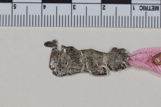 Hearst Museum object titled Milagro, accession number 3-28924b, described as Kneeling male figure, lg. -5.2cm