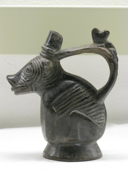 Hearst Museum object 1 of 5 titled Effigy jar, accession number 16-18195, described as Effigy jar, zoomorphic; squatting dog in black ware; strap handle with modeled animal; damaged ring base, damaged spout; height: 16 cm.