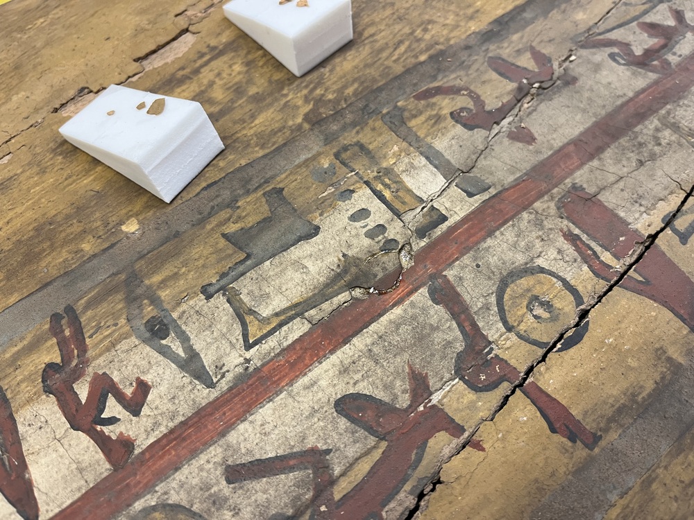 Hearst Museum object 54 of 167 titled Coffin, accession number 6-19912, described as Wooden anthropoid coffin. Inscription running down center of lid. Determined by Kea Johnston to probably be the outer coffin of Iwefaa (6-19928, 12-11039). According to Kea Johnston, "This coffin belonged to a man named Iwefaa, whose name is inserted in the middle of the spells written in the two columns on the front. This coffin is likely the outer coffin for PAHMA 6-19928 based on the similarity of the owner's name, unusual costume, and the paleography of the inscription. Both coffins were purchased on the antiquities market by George Reisner for Phoebe A Hearst. However, stylistically, they are very similar to a set of coffins known to have come from the site of Akhmim, which was excavated in the 1880s by Gaston Maspero, and which has heavily looted for the antiquities market during this decade." "The pectoral vignette between the text and the collar shows the deceased standing before squatting baboon and is the source of our logo. The hieroglyph for 'sky' is above their heads, and the side borders are formed by a pyramid and the symbol for the West.