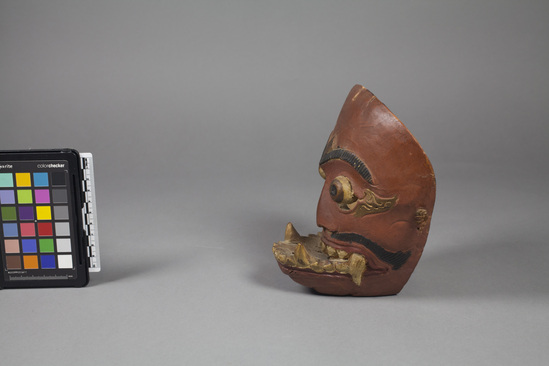 Hearst Museum object 4 of 4 titled Mask, accession number 18-1194, described as Mask, wood, carved and painted; jutting lower jaw and fang-like teeth; tan, gold, black and red. Used in dance. 18.0 cm.