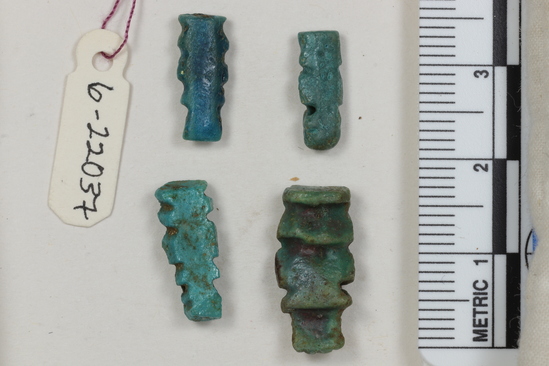 Hearst Museum object 12 of 22 titled Amulets, accession number 6-22037, described as amulets, of blue faience, and one pyramidal seal of steatite