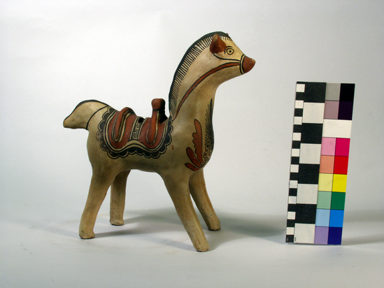 Hearst Museum object titled Figurine, accession number 3-23026, described as horse, pottery; slip decorated, red and black slip on buff ground; saddle decoration with floral design on chest of horse; slot in back; 26.0 cm