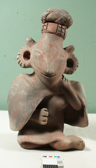 Hearst Museum object titled Figurine, accession number 3-3664, described as Red pottery effigy of seated woman wearing cape; enormous earrings