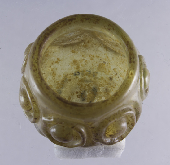 Hearst Museum object 20 of 20 titled Jar, accession number 5-14497, described as Glass jar, mold blown? Pale golg with ochre specks. 7 circle motifs around sides.