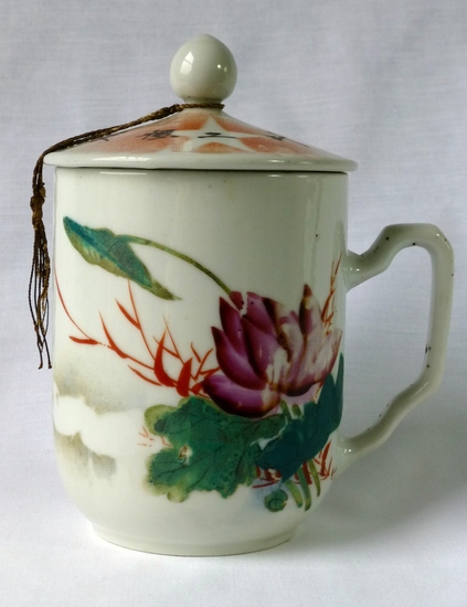 Hearst Museum object titled Mug and lid, accession number 9-23485a,b, described as Hand-painted and spray-painted with a purple lotus flower and egrets. Inscription: “Energetically produce” (努力生產 Nuli shengchan). On the lid: “Support Industrialization” (支援工叶（业）化Zhiyuan gongyehua). Kiln mark: “Product of Ceramic cooperative, Liling” (醴陵陶瓷合作社出品 Liling taoci hezuoshe chupin)