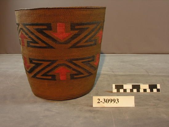 Hearst Museum object 3 of 3 titled Basket, accession number 2-30993, described as Cylindrical, twined spruce root, exterior false embroidery of grass stems dyed dark brown and orange: "Z" and arrow designs; interior green, brown and black bands of dyed spruce roots. Cardboard strip sewn to base.