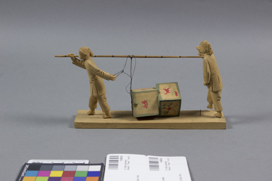 Hearst Museum object titled Figurines, accession number 9-6802a,b, described as Wooden model: (a) 2 men on stand, carrying (b) load; L. 6 1/2”.