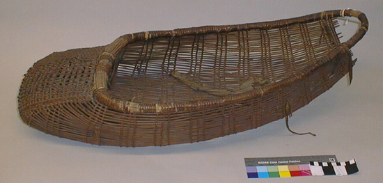 Hearst Museum object 1 of 2 titled Cradle, accession number 1-11802, described as Baby basket; twined. Warp and weft are peeled Hazel (Corylus cornuta californica). Rim of many slender hazel shoots bound with shreddy grape? Bent asymmetrically.