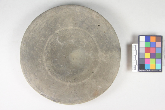 Hearst Museum object titled Basin, accession number 8-1719, described as Dark gray basin, wide rim. Description from Matteucig (1951): Plate; height: 4.2 cm; diameter: 19.3 cm (see Matteucig's plate II, 1). Gray impasto. Clay light gray with sandy particles; dull dark gray surface, almost like gray bucchero. Shape as in no. 8-1717.