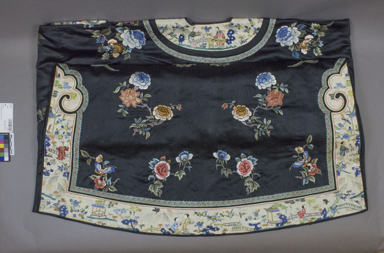 Hearst Museum object titled Robe, accession number 9-22729, described as Tibetan, black silk robe embroidered with peony and plum (salmon and blue) blossoms, plus butterflies in corner of each front panel.  garment opens at center front and has 3 golden, ball buttons and black cord loop closures.  neck, sleeves, side slits and hem are bordered with elaborately embroidered ecru bands and commercial braid.  sleeve bands feature peonies and butterflies.  neck side-slits and hem feature scenes of women standing in the midst of trees, flowers, near water with bridges, rocks, butterflies, small garden shelters, and in shades of blue, green, peach, copper, aqua, salmon, old gold.  braid enhancement in aqua with salmon, yellow and green flower pattern.  fully lined with black silk.