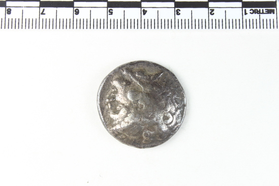 Hearst Museum object 4 of 6 titled Coin: ar tetradrachm, accession number 8-4743, described as Coin; AR; Tetradrachm; Greek. 16.33 grams, 28 mm. Alexander the Great, 336-323 BC. Obverse: Head of Heracles r. Reverse: ΑΛΕΞΑΝΔΡΟΥ, Zeus seated l., eagle on outstretched r. hand, scepter in l.