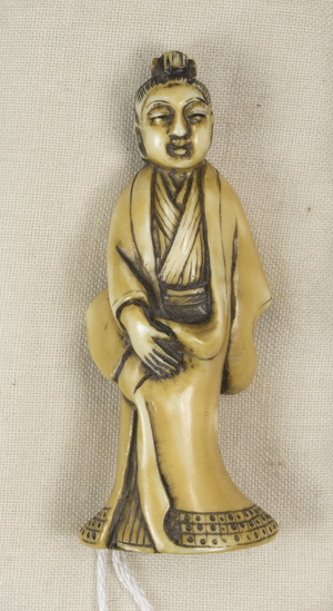 Hearst Museum object 6 of 12 titled Netsuke, accession number 9-18783, described as Netsuke; figure of man, standing, with long robe, flaring at feet; right hand holding robe, left hand concealed; H 6.0 cm X W 2.3 cm