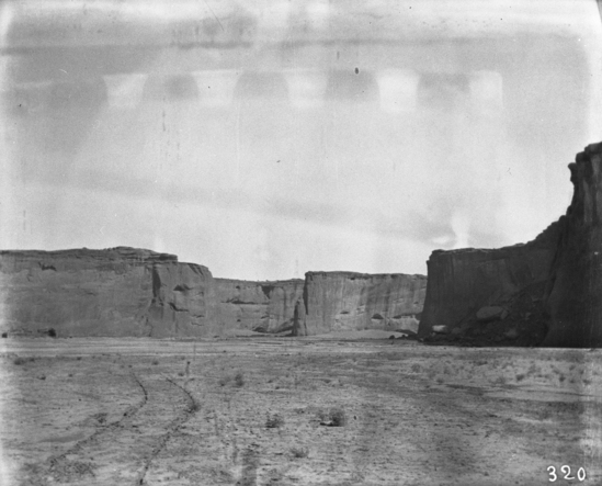 Hearst Museum object titled Black-and-white negative, accession number 15-320, described as canyon bottom with wagon tracks; cliffs in background