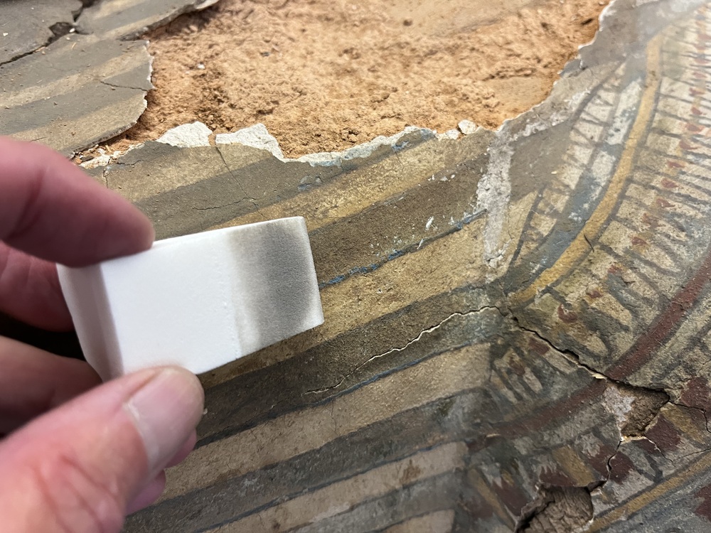 Hearst Museum object 102 of 167 titled Coffin, accession number 6-19912, described as Wooden anthropoid coffin. Inscription running down center of lid. Determined by Kea Johnston to probably be the outer coffin of Iwefaa (6-19928, 12-11039). According to Kea Johnston, "This coffin belonged to a man named Iwefaa, whose name is inserted in the middle of the spells written in the two columns on the front. This coffin is likely the outer coffin for PAHMA 6-19928 based on the similarity of the owner's name, unusual costume, and the paleography of the inscription. Both coffins were purchased on the antiquities market by George Reisner for Phoebe A Hearst. However, stylistically, they are very similar to a set of coffins known to have come from the site of Akhmim, which was excavated in the 1880s by Gaston Maspero, and which has heavily looted for the antiquities market during this decade." "The pectoral vignette between the text and the collar shows the deceased standing before squatting baboon and is the source of our logo. The hieroglyph for 'sky' is above their heads, and the side borders are formed by a pyramid and the symbol for the West.