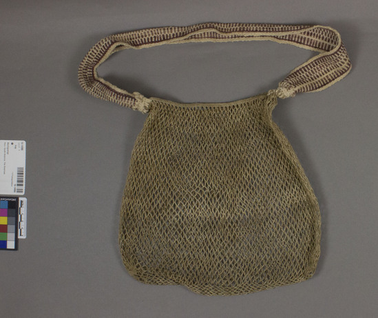 Hearst Museum object titled Bag, accession number 16-14986, described as Netted bag ("tsagi"); close mesh with even spaced knotting; netting is tivana fiber; carrying strap of woven cotton white with brown; 59 cm length, 28 cm width