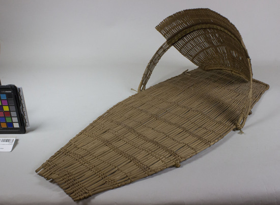 Hearst Museum object 4 of 5 titled Cradle, accession number 1-67928, described as Open plain twined.  Decoration: horizontal band with white diamond pattern (indicating that the cradle was intended for a girl) in worsted on hood.  Hood is attached to cradle board with twine. Made of peeled shoots.